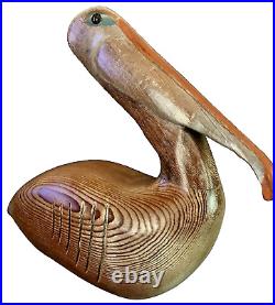 Vintage Hand Carved Solid Wood Pelican Sculpture withglass eyes. Signed by artist