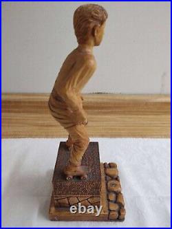 Vintage wood carving figure roller skates on pedestal