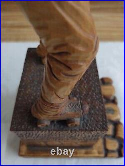 Vintage wood carving figure roller skates on pedestal